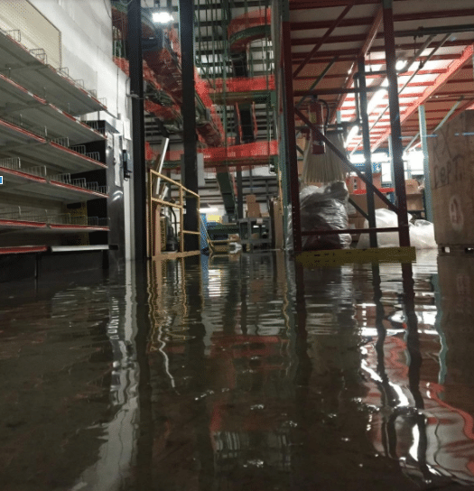 A flooded warehouse with inches of standing water.